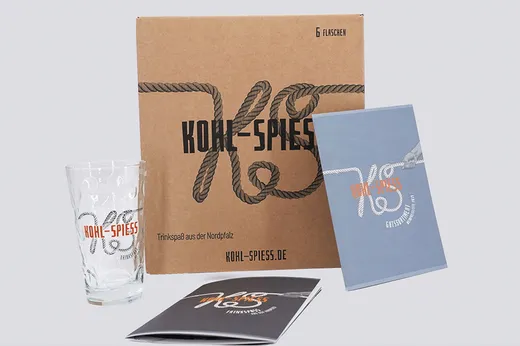 Eine Wein-Sechserpack-Verpackung, ein Weinglas und eine Broschüre für Kohl-Spies mit Seilmotiven.