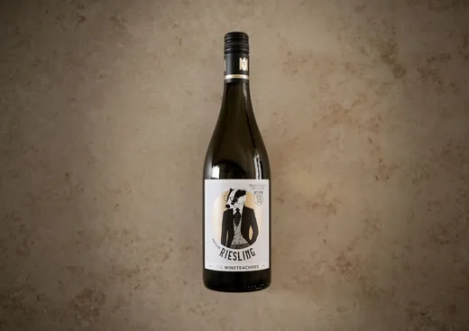 Eine Flasche Riesling steht aufrecht auf einer marmorierten, hellbraunen Oberfläche. Auf dem Etikett ist ein Tier in einem Anzug abgebildet, dazu stehen die Aufschriften „Proffessor Riesling“ und „The Wineteachers“ sowie weiterer Kleingedrucktes.