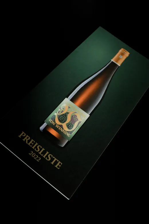 Eine dunkelgrüne Broschüre mit dem Foto einer Weinflasche mit der Aufschrift „Von Winning“ auf dem Einband. Am unteren Rand des Einbands ist in goldenen Buchstaben der Schriftzug „PREISLISTE 2022“ zu sehen.